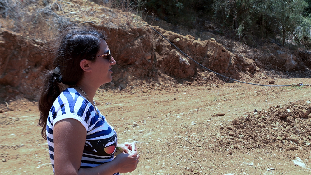 Christiane Assaf stands next to her expropriated land within the dam project area