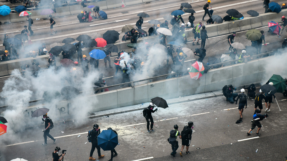 Protesters react after police fired tear near the government headquarters on Saturday