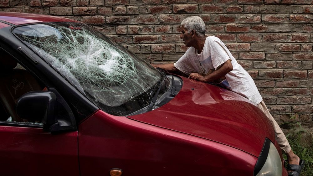A Kashmiri man inspects his car which was allegedly damaged by Indian security forces after Friday clashes