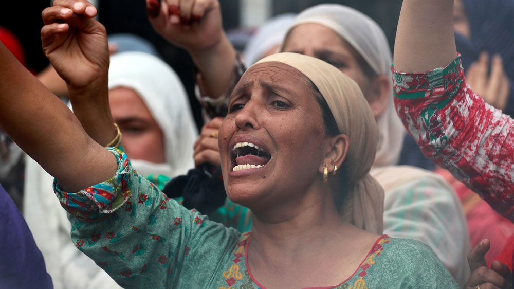 A woman shouts slogans during a protest following restrictions in Srinagar