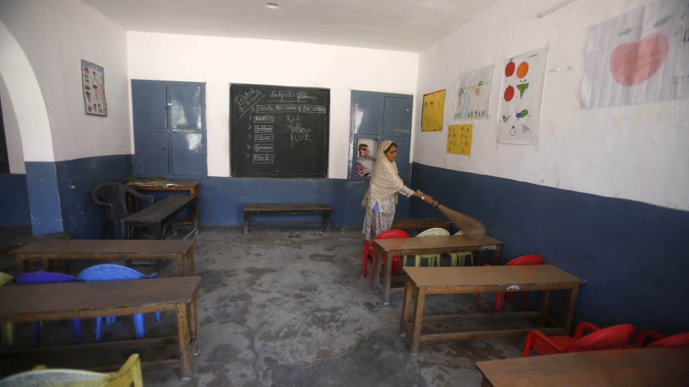 A Kashmiri school staff member cleans a deserted classroom in Srinagar, Indian-controlled Kashmir