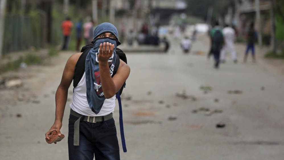 A Kashmiri prepares to catch a stone during an anti-India protest Srinagar