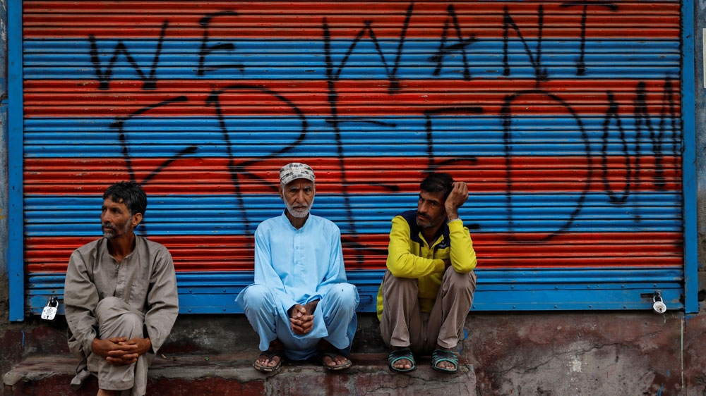 Kashmiri men wait before Eid-al-Adha prayers in Srinagar