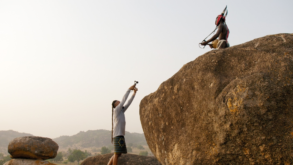 Wanlov the Kubolor, a rapper and musician, holds up a camera during a music video shoot
