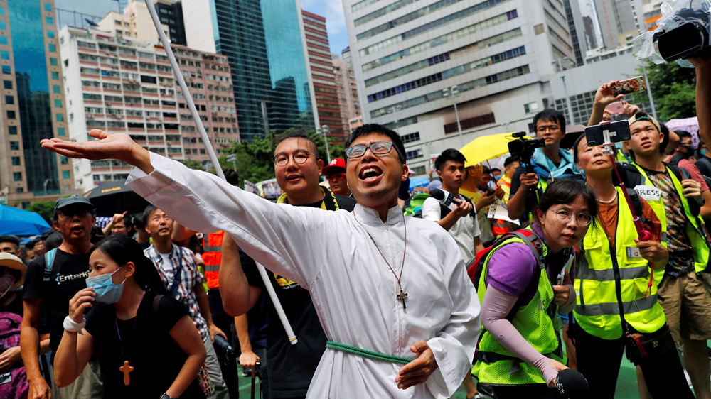 A priest urges people to join the protest in Hong Kong