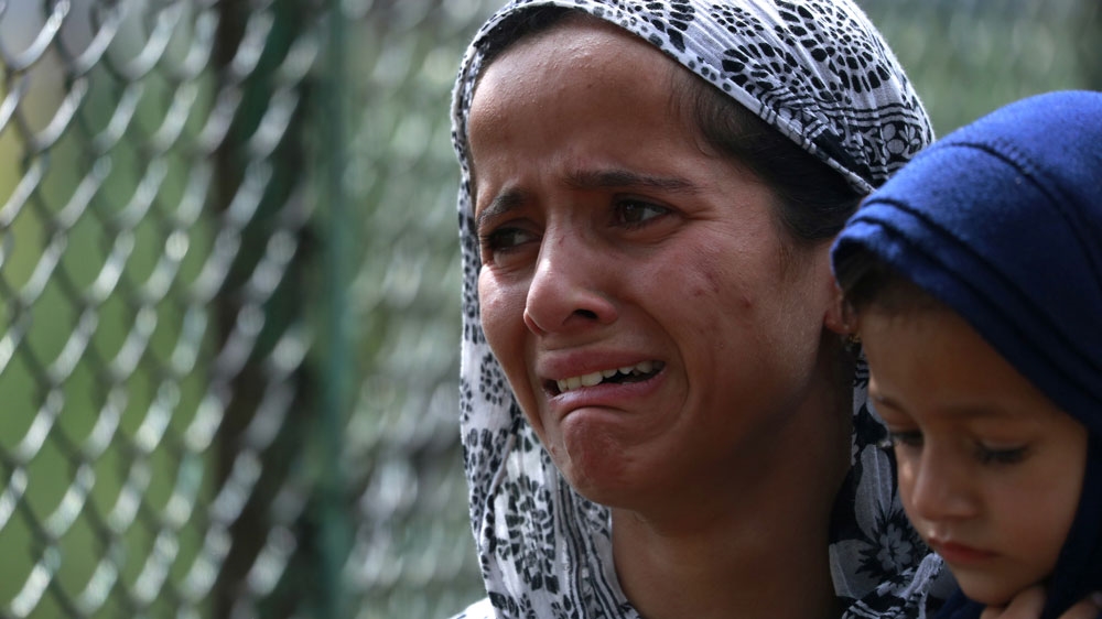 A Kashmiri girl cries as she carries a baby during clashes between protesters and Indian security forces in Srinagar
