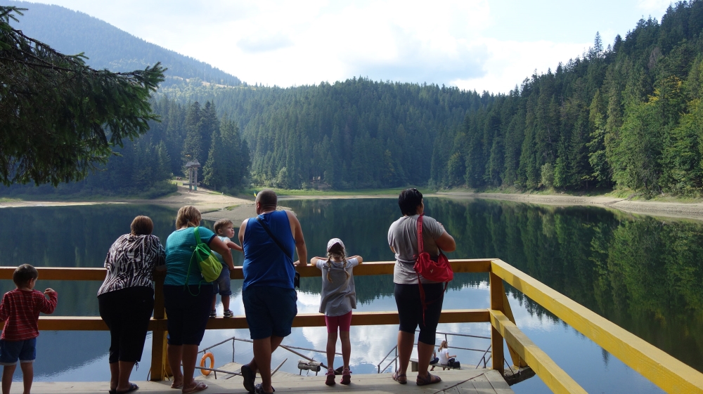 A family takes a moment to enjoy Synevyr, the largest lake in the Carpathian mountains of Ukraine