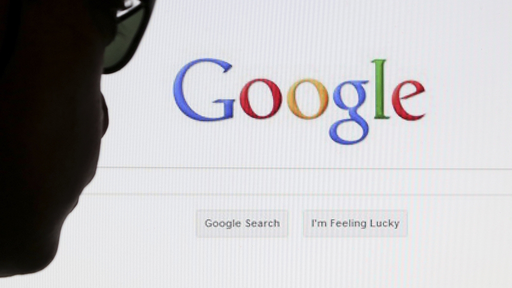 A computer user poses in front of a Google search page in this photo illustration taken in Brussels May 30, 2014