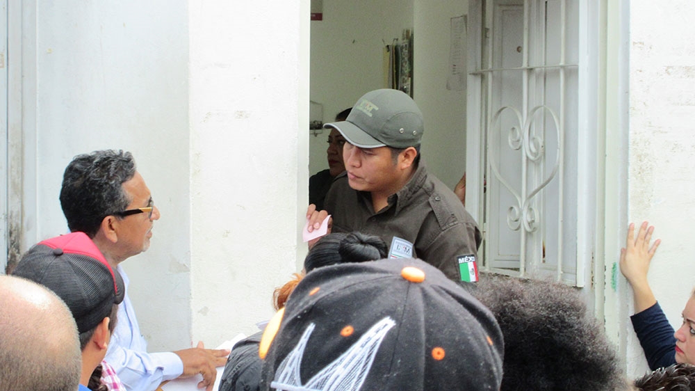 Migrant rights lawyer Luis Garcia, left, speaks with an official at an immigration office in Tapachula on behalf of a group of migrants and asylum seekers