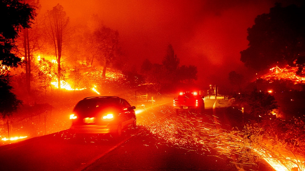 Embers fly across a roadway as the Kincade Fire burns through the Jimtown community of Sonoma County, California