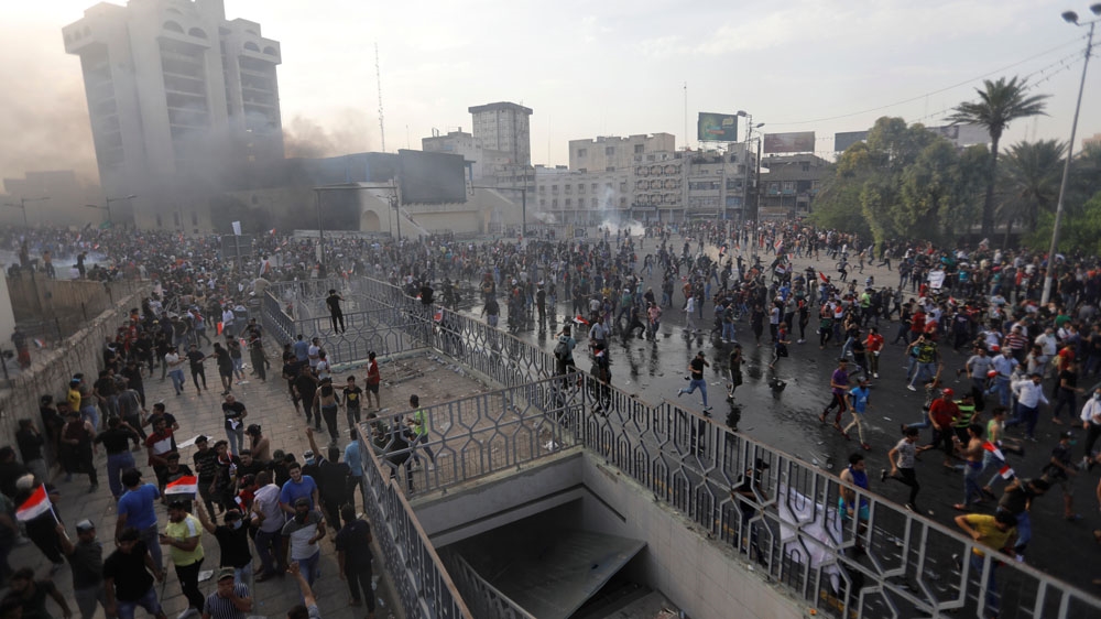 Demonstrators disperse as Iraqi Security forces use tear gas during a protest
