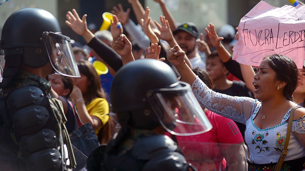 People protest against a petrol price increase ordered by the government to secure an IMF loan in front of riot police in Guayaquil, Ecuador