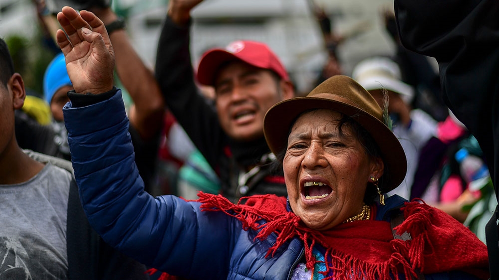 Indigenous people demonstrate outside the House of Culture in Quito while other protesting members of the indigenous community gather in the building