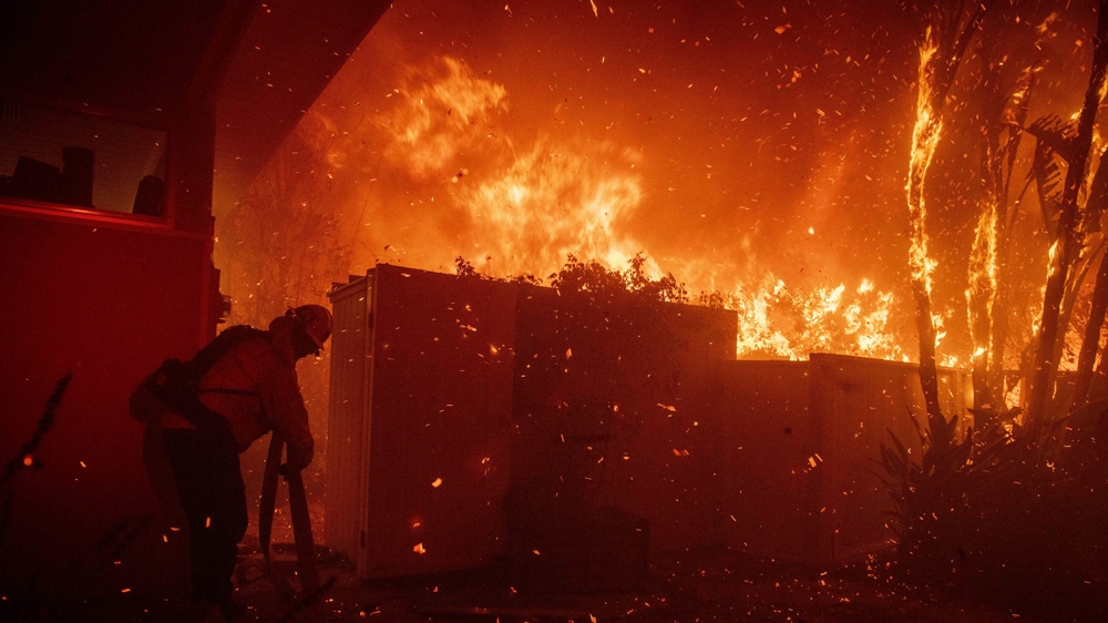 Firefighters tried to save a home in western Los Angeles in a fire that sparked on Monday