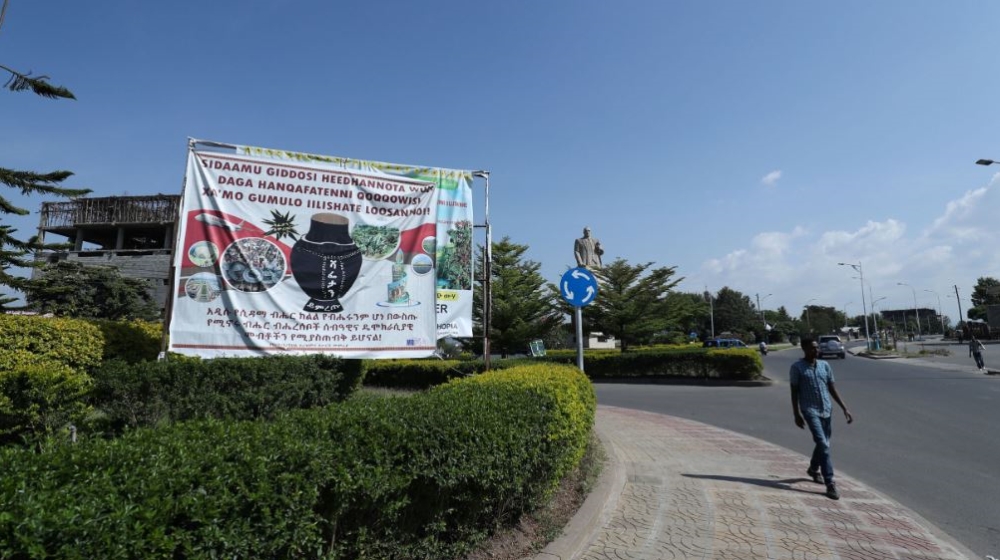 A pedestrian walks past a billboard with a symbol of the Sidama referendum in Hawassa