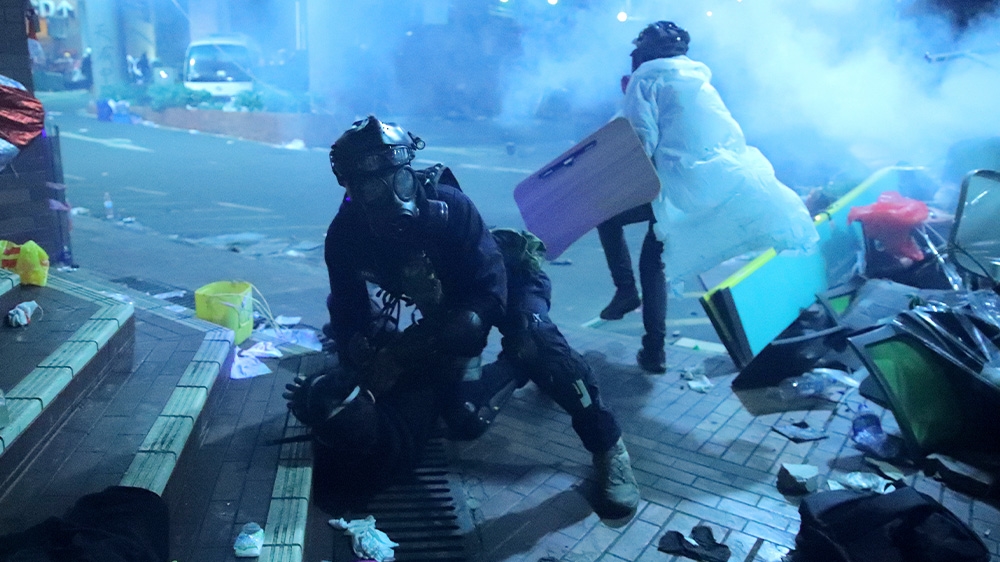A policeman in riot gear detains a protester outside Hong Kong Polytechnic University as police stormed the campus early on Monday morning.
