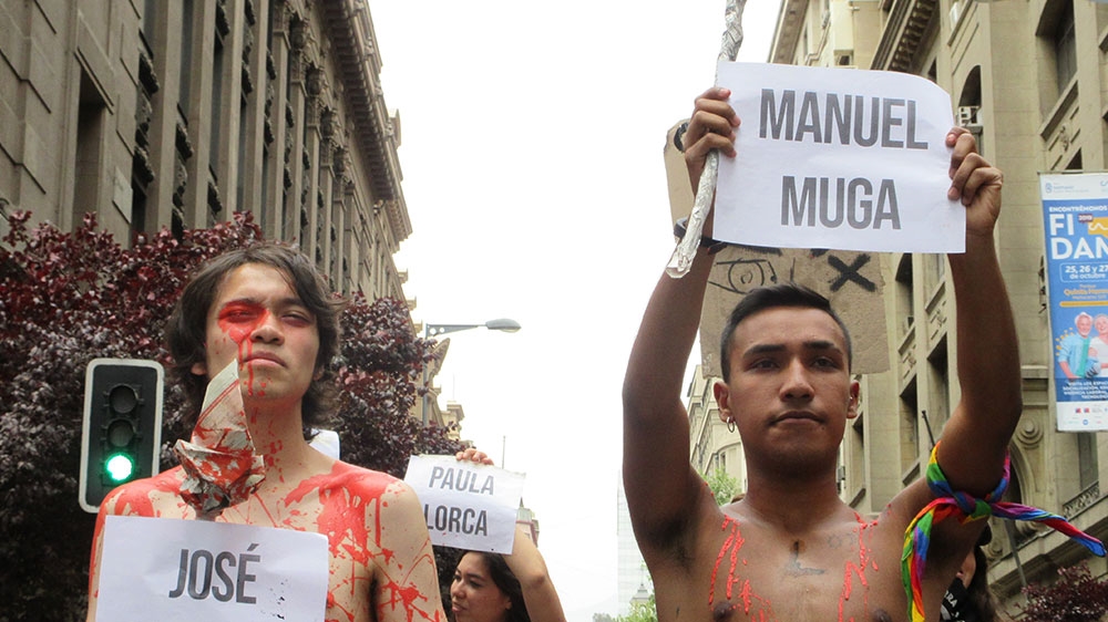 Students carry the names of the more than 20 people killed during the three weeks of upheaval in Chile through downtown Santiago