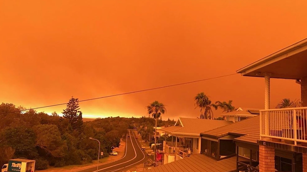 The sky turns orange in Port Macquarie about 400 kilometres north of Sydney. The authorities in NSW have declared a state of emergency [Mireya Reyes via Reuters]