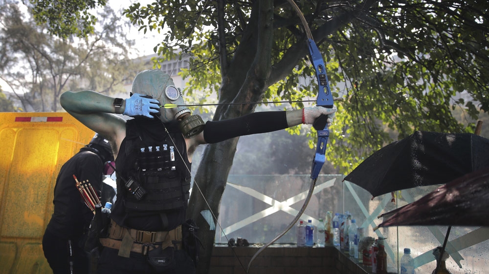 A protester prepares to fire an arrow during a confrontation with police at the Hong Kong Polytechnic University