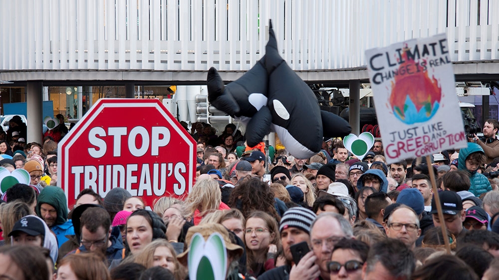 An inflatable orca is pictured next to a stop sign protesting the Canadian federal government’s purchase of an oil pipeline project, during a climate strike rally in Vancouver