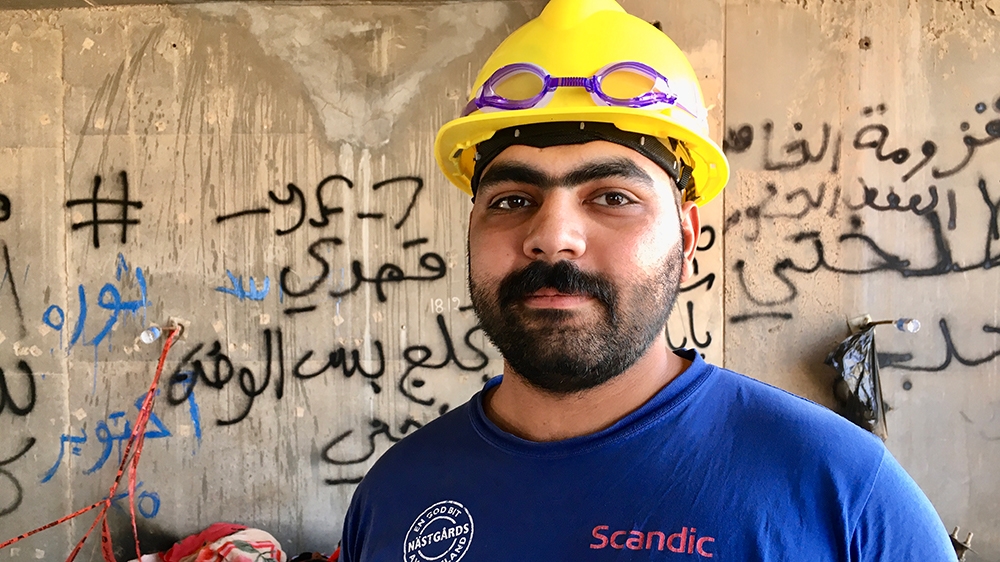  Abdullah stands inside one of the building’s makeshift bedrooms [Sofia Barbarani/Al Jazeera]