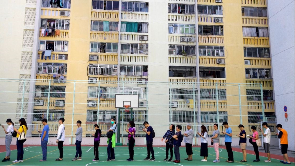 People line up to vote outside a polling place at a housing estate in Hong Kong