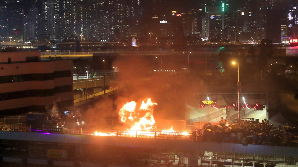 Protesters hurl Molotov cocktails towards armoured vehicles during violent confrontations at the Hong Kong Polytechnic University
