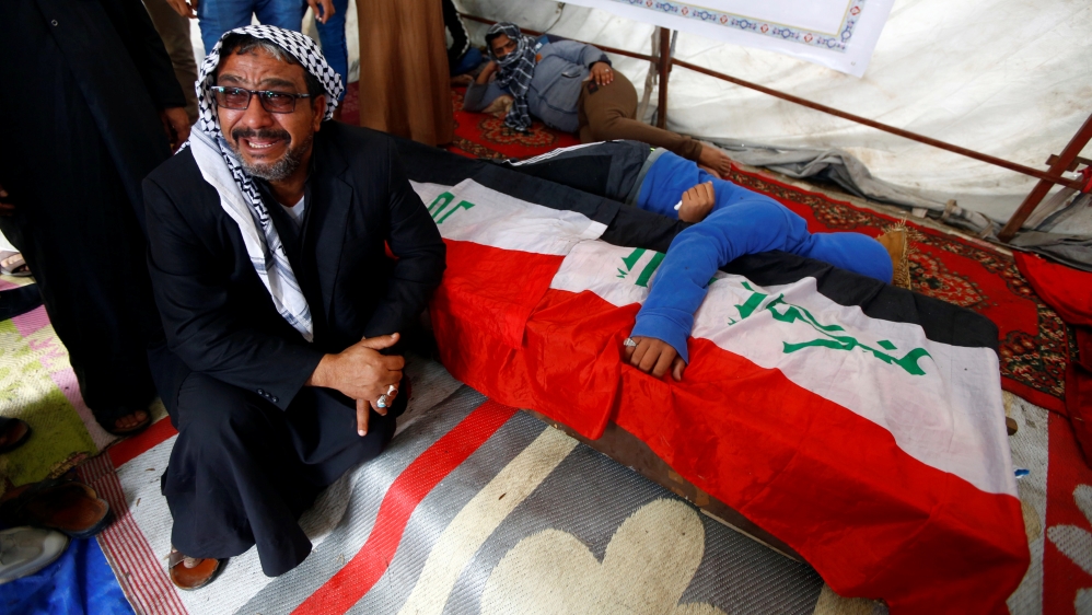 Relatives react by the coffin of a demonstrator who was killed at an anti-government protest overnight in Najaf