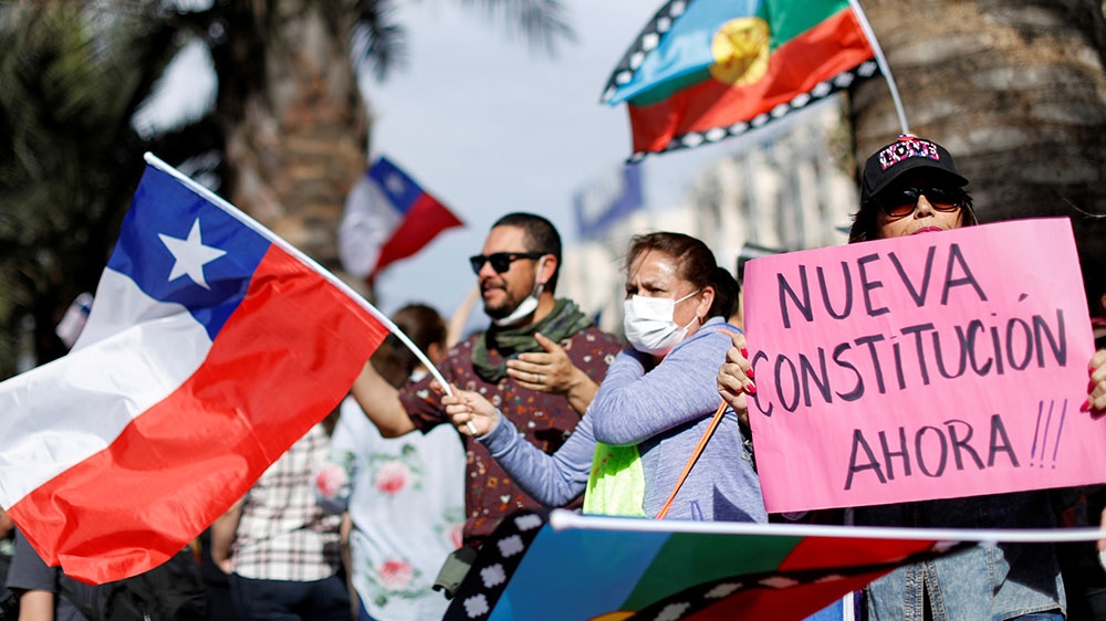 A demonstrator holds a placard reading ‘New constitution now’ during a protest against Chile’s government in Santiago, Chile