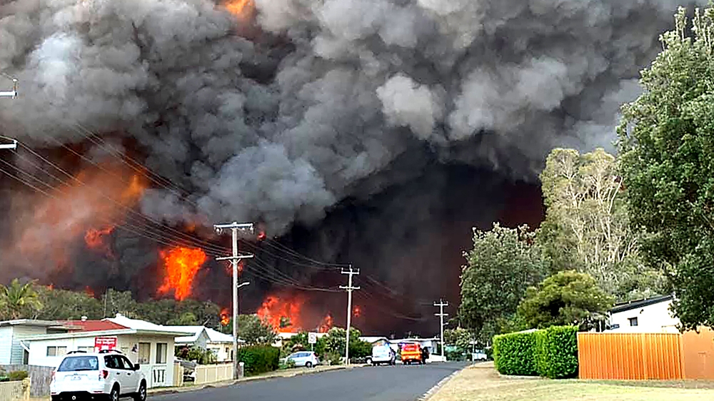 This handout picture taken and received from Kelly-ann Oosterbeek on November 8, 2019 shows flames from an out of control bushfire seen from a nearby residential area in Harrington, some 335 kilometer