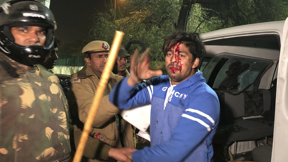 Policemen detain an injured student outside Jamia Millia Islamia university during a protest against Citizenship Amendment Act in New Delhi, India, Sunday, Dec. 15, 2019. Protests have been continuing