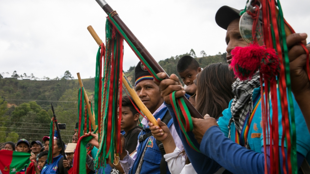 At the funeral of two assassinated Guards in August, members hold their wooden staves as they sing the Guardia anthem