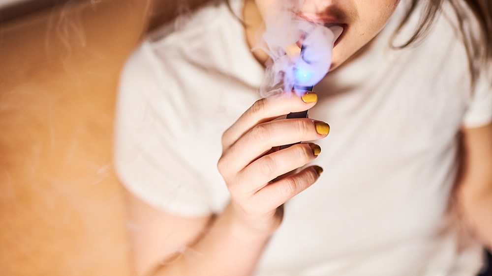 A person smokes a Juul Labs Inc. e-cigarette in this arranged photograph taken in the Brooklyn Borough of New York, U.S., on Thursday, Dec. 20, 2018