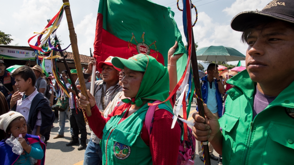During a demonstration on the Pan-American highway on the first day of the national strike, a woman from the Guard raises her staff into the air as leaders read victims’ names