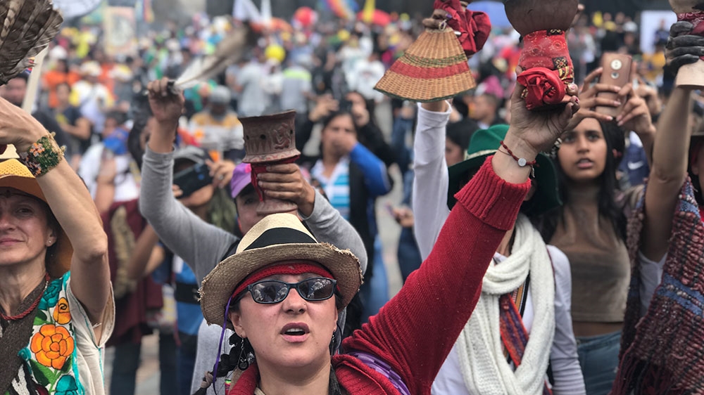 indigenous women with pots of incense cleanse Bogota’s main square