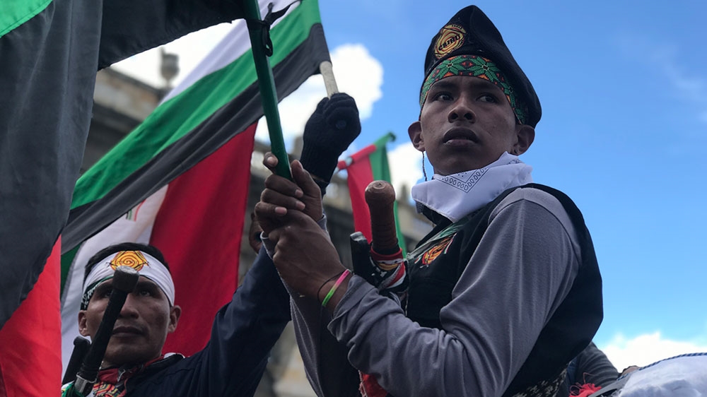 A member of the Indigenous Guard holds a flag in Bogota’s main square, Plaza Bolivar