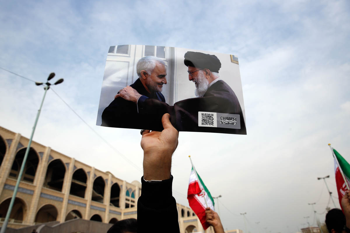 epa08099933 A person as holds a picture showing Iranian Supreme Leader Ayatollah Ali Khamenei (R) greeting Iranian Revolutionary Guards Corps (IRGC) Lieutenant general and commander of the Quds Force