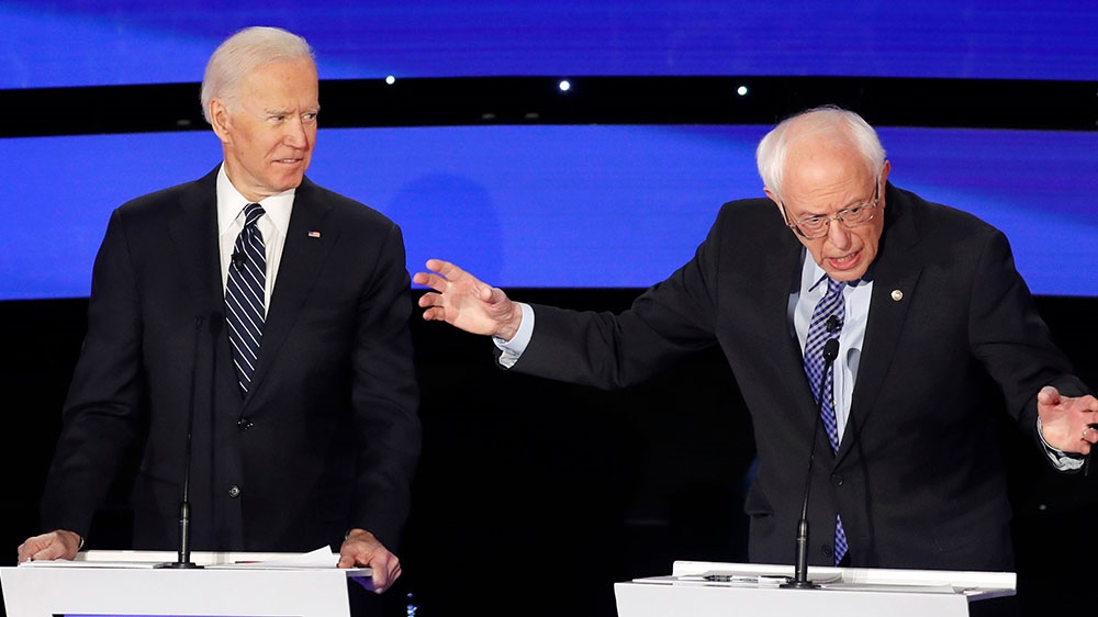 Democratic 2020 US presidential candidate and former Vice President Joe Biden smiles as Senator Bernie Sanders speaks during the seventh Democratic 2020 presidential debate at Drake University in Des Moines, Iowa