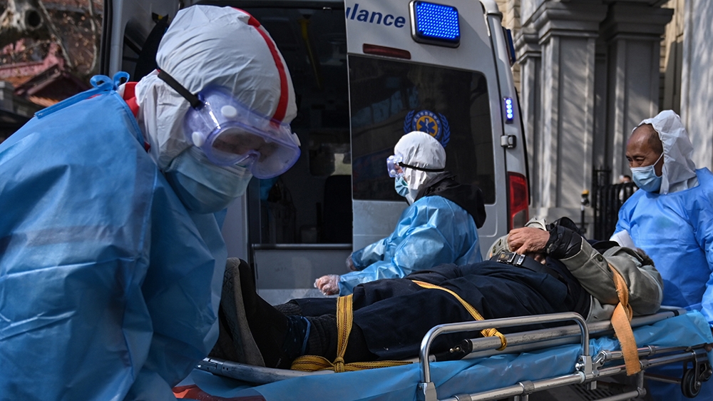 Medical staff in protective clothes are seen carrying a patient from an apartment suspected of having the virus in Wuhan, in Hubei province on January 30, 2020. - The World Health Organization, which