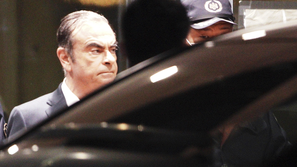 Former Nissan Chairman Carlos Ghosn, right, walks out with security guards from Tokyo Detention Center Thursday, April 25, 2019, in Tokyo
