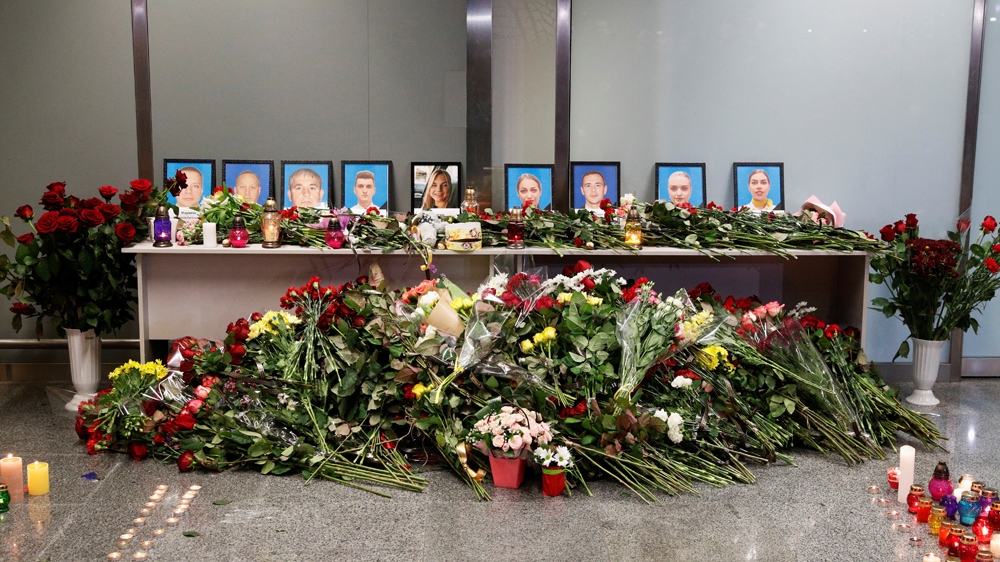 Flowers and candles begin to pile up at a memorial to the flight crew at Boryspil International Airport near Kyiv, Ukraine