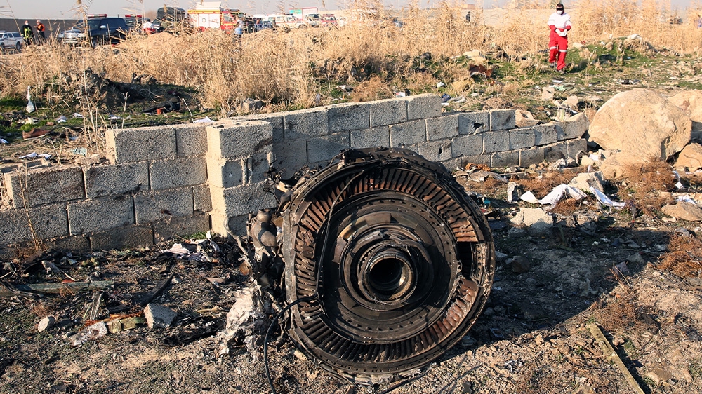 One of the engines from the crashed plane lies among the wreckage outside Tehran.