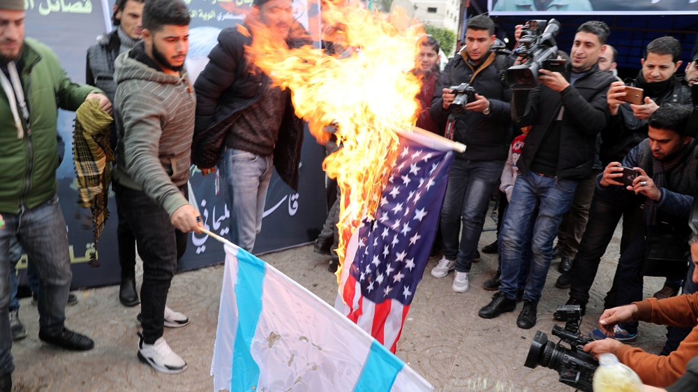 Palestinians burn US and Israeli flags at a memorial ceremony for Soleimani in Gaza