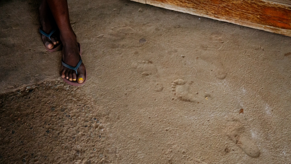 A child walks past small footprints in the cement at the children’s home