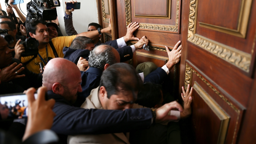 Legislators push one of the entrances of Venezuela’s National Assembly building in Caracas