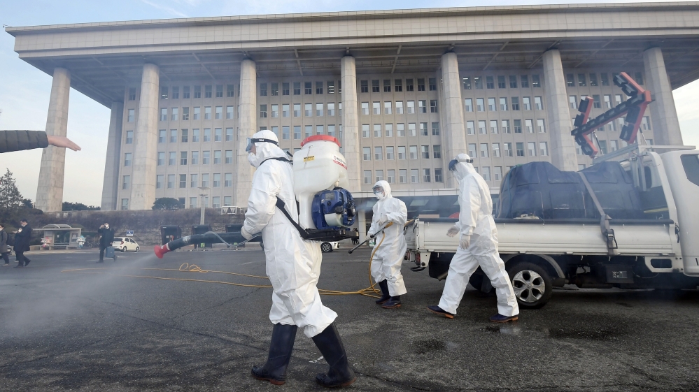 Workers spray disinfectant as part of preventive measures against the spread of the coronavirus, at the National Assembly in Seoul on Monday