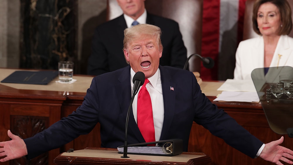 Trump gestures near Speaker of the House Nancy Pelosi and Vice President Mike Pence during his State of the Union address