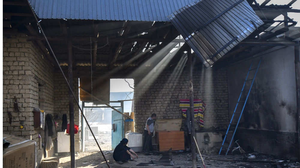 Local residents are inside their burned house after the conflict in Shor-Tube