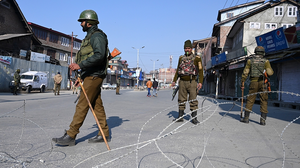 Indian paramilitary trooper stands guard at a checkpoint during a one-day strike called by Jammu and Kashmir Libration Front (JKLF) to demand the return of the remains of Afzal Guru, who was executed