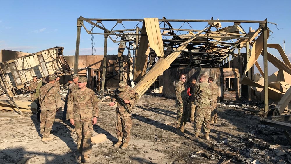 US soldiers inspect the site where an Iranian missile hit at Ain al-Assad air base in Iraq.